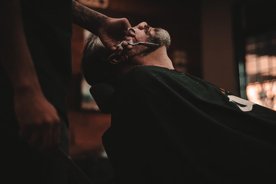 A barber working at the chair, mid-cut